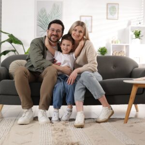 Portrait of happy family on sofa at home